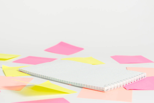 Pink and yellow stickers and notebook lies on a light background. - Fotografie, Obrázek