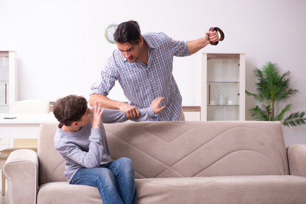 Отец избивает и наказывает своего сына - Фото, изображение