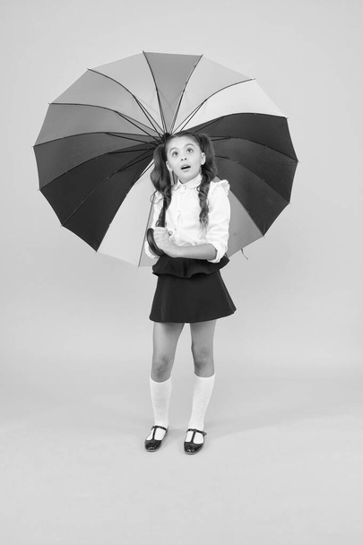 On way to school. Fashion accessory. Rainy september. Accessory for rainy day. Fancy schoolgirl. Girl with umbrella. Rainy day. Happy childhood. Kid happy with umbrella. Fall weather forecast - Фото, зображення