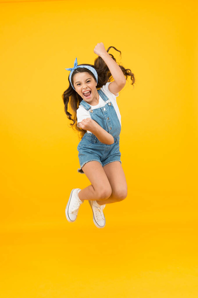 Totally happy. Energy inside. Feeling free. Summer holidays. Jump of happiness. Small girl jump yellow background. Enjoy freedom. Childrens day concept. Spirit of freedom. Active girl feel freedom - 写真・画像