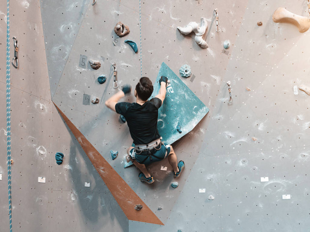 A man climbing in boulder gym in the wall. - Foto, imagen