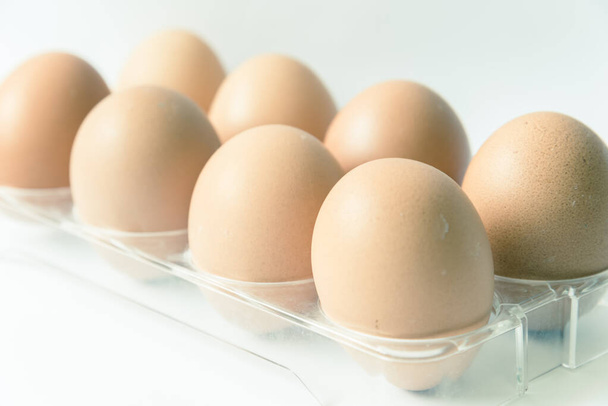 Filtered image studio shot raw brown eggs on plastic package isolated on white - Photo, Image