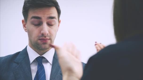 Cute office woman is reporting to her boss, explaining something, but he doesnt want to listen, showing by his face expression that she is saying stupid things.. - Záběry, video