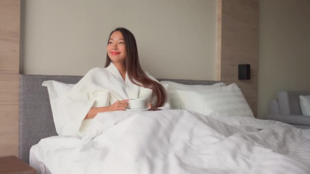 footage of beautiful asian woman with cup of hot drink relaxing at home - Footage, Video
