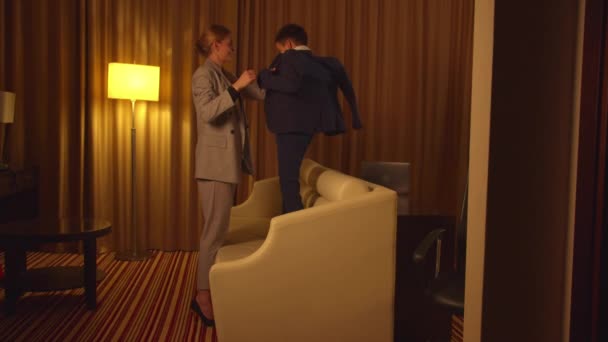 Matka si oblékla sako na malého chlapce v hotelu  - Záběry, video