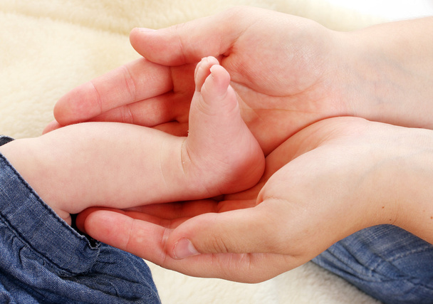 baby voeten in handen van de Moederdag. - Foto, afbeelding