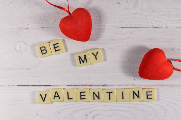 Corações vermelhos e texto "Be my Valentine" em fundo de madeira branca
 - Foto, Imagem