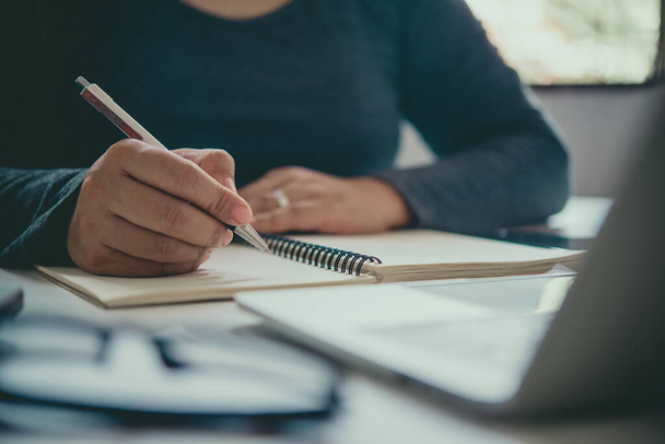 La main d'un homme tenant un stylo et prenant des notes dans un carnet
. - Photo, image