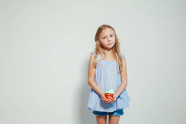 beautiful little girl blonde with cake and candy portrait of food - Photo, Image