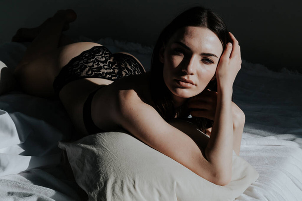 beautiful woman in underwear lies on the bed in the bedroom - Photo, Image