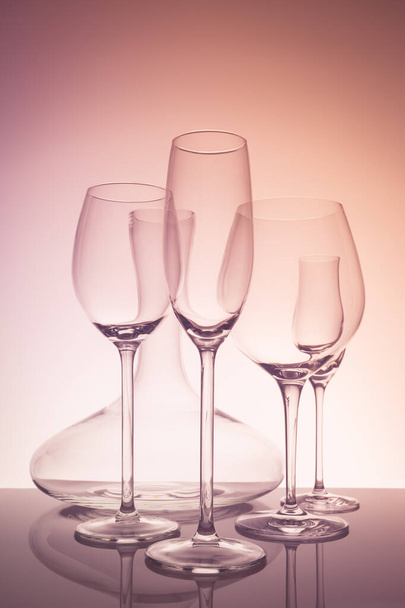 Selección de cristalería con vino, champán, copas de licor y decantador sobre fondo creativo
 - Foto, Imagen