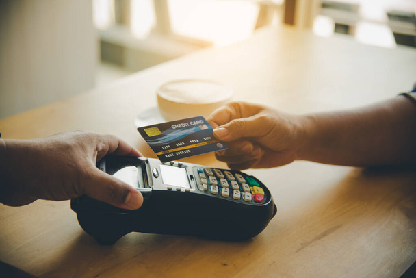 A hitelkártya használatával történő fizetés kézzelfogható közelsége a hitelkártya elküldésével  - Fotó, kép