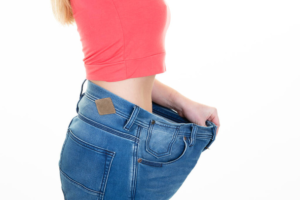 Mladá žena v nadměrné velikosti kalhoty štíhlé břicho ve studiu shot - Fotografie, Obrázek