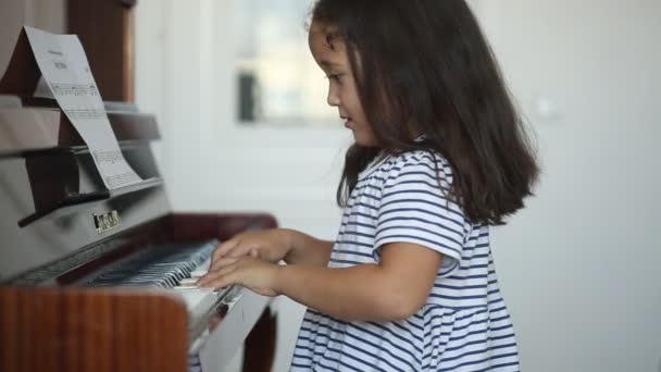 Kazašské asijské děvčátko se učí hrát na klavír - Záběry, video