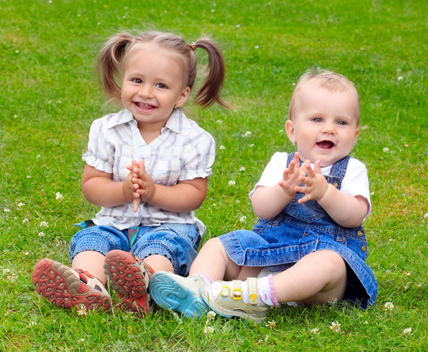 δύο χαρούμενα παιδιά στο πράσινο λιβάδι. - Φωτογραφία, εικόνα