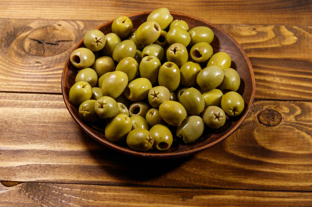 Piatto con olive verdi sul tavolo di legno
 - Foto, immagini