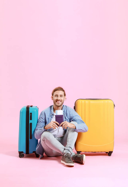 Young tourist with luggage on color background - Photo, Image