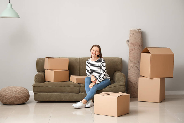 Счастливая молодая женщина с коробками в новом доме
 - Фото, изображение