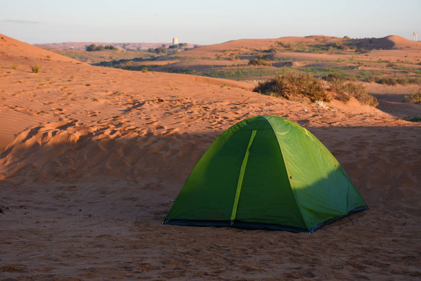 Zielony namiot na rodzinny kemping na wydmach pustyni Zjednoczonych Emiratów Arabskich. Zabawa rodzinna, odizolowana, cicha, sucha. - Zdjęcie, obraz