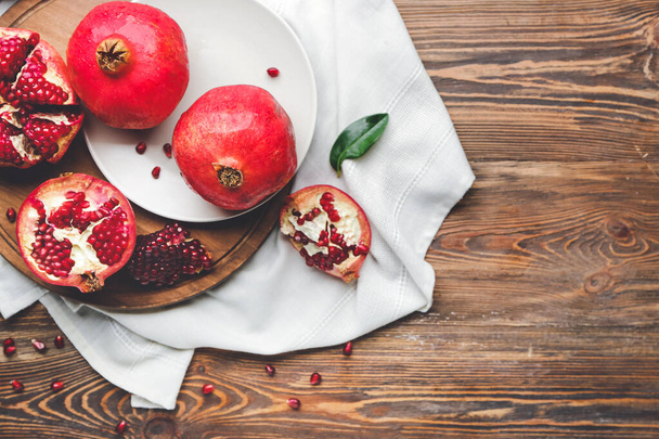 Deska s chutným granátovým jablkem na dřevěném stole - Fotografie, Obrázek