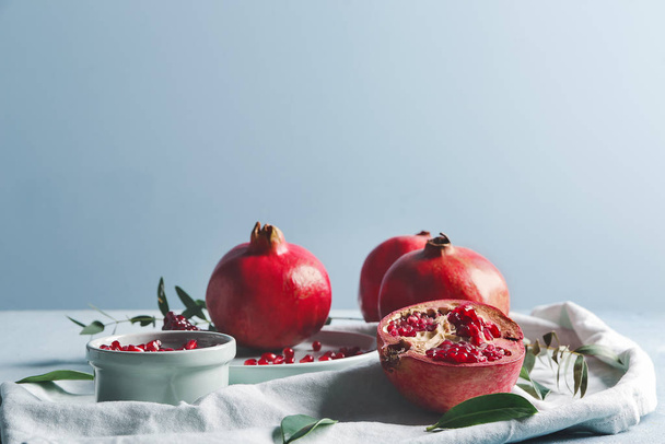 Chutné granátové jablko s listy na bílém stole - Fotografie, Obrázek
