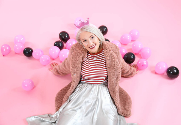 Cool mujer madura de moda con globos de aire sobre fondo de color
 - Foto, Imagen