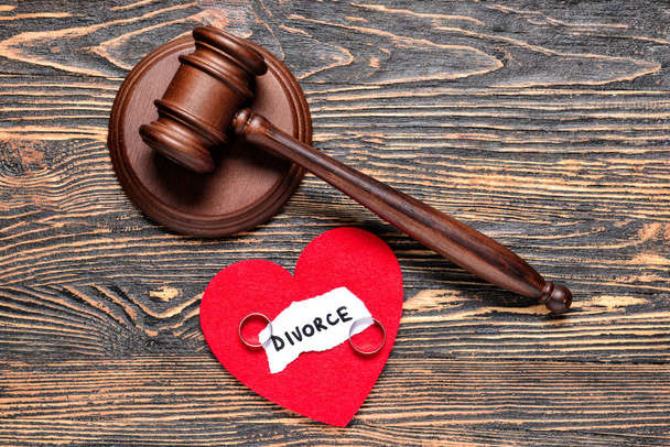 Judge's gavel, heart and rings on wooden background. Concept of divorce - Photo, Image