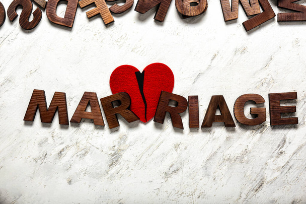 Palabra de matrimonio y corazón roto sobre fondo claro. Concepto de divorcio
 - Foto, Imagen