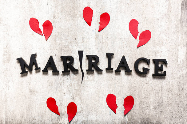 Word MARRIAGE with crack and broken hearts on grey background. Concept of divorce - Photo, Image