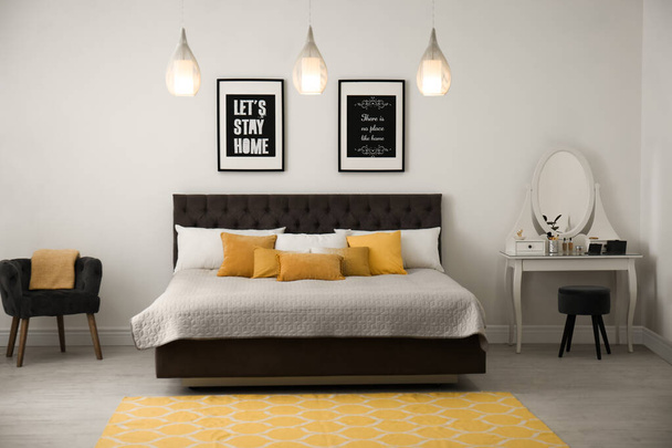 Stylish room interior with large comfortable bed - Фото, зображення