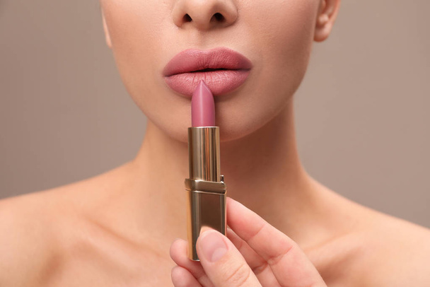 Woman with pink lipstick on brown background, closeup - Fotoğraf, Görsel