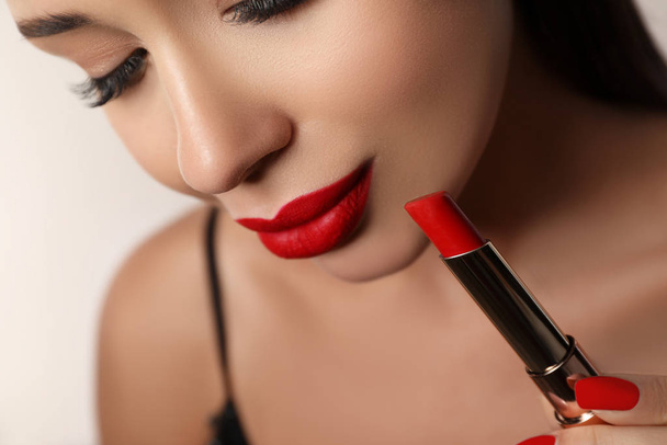 Beautiful woman with red lipstick on light background, closeup - Foto, Imagem