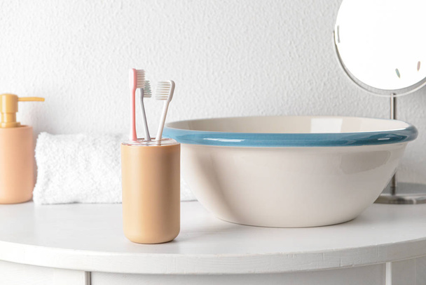 Holder hammasharjat pöydällä kylpyhuoneessa
 - Valokuva, kuva