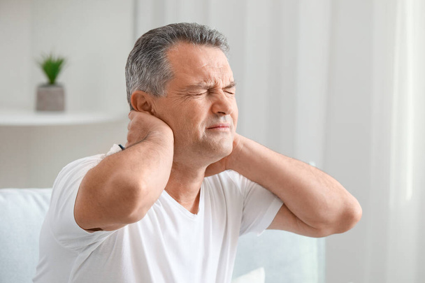 Dojrzały człowiek cierpiący na bóle szyi w domu - Zdjęcie, obraz