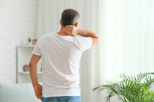 Dojrzały człowiek cierpiący na bóle szyi w domu - Zdjęcie, obraz