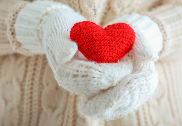 Woman with knitted mittens and red heart, closeup. Valentines Day celebration - Fotoğraf, Görsel