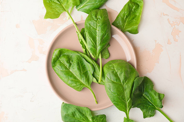 Plate with fresh green spinach on table - Фото, зображення