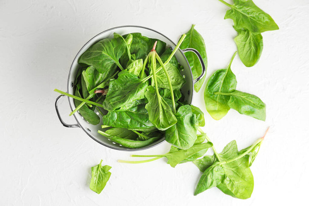 Colander with fresh green spinach on table - Фото, зображення