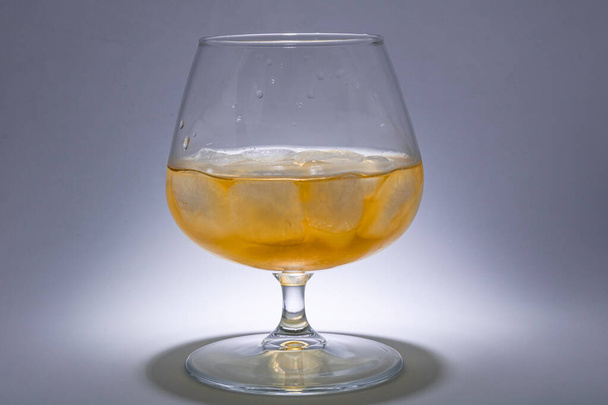 Szklankę whisky z lodem. Instalacja artystyczna z oświetleniem od - Zdjęcie, obraz