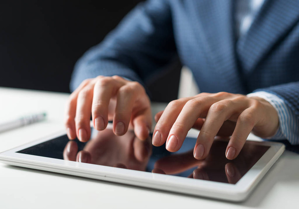 Zavření mužských rukou při psaní na digitální dotykové obrazovce tabletu. Muž v obleku sedí u stolu a pracuje v tabletovém počítači. Manažer na pracovišti v kanceláři. Obchodní a digitální technologie - Fotografie, Obrázek