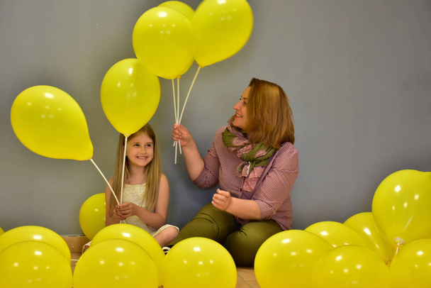 жінка і дівчина з жовтими кульками
, - Фото, зображення