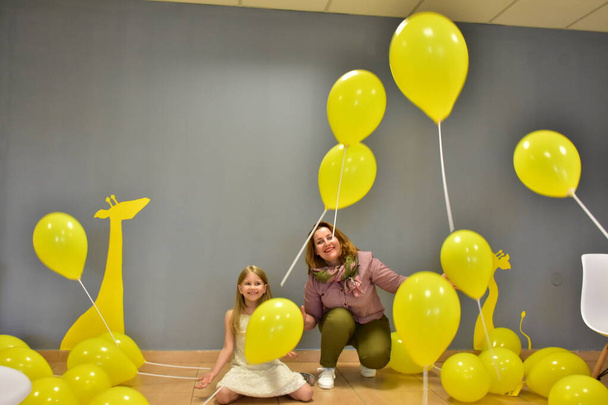 mujer y niña con balones amarillos, - Foto, imagen
