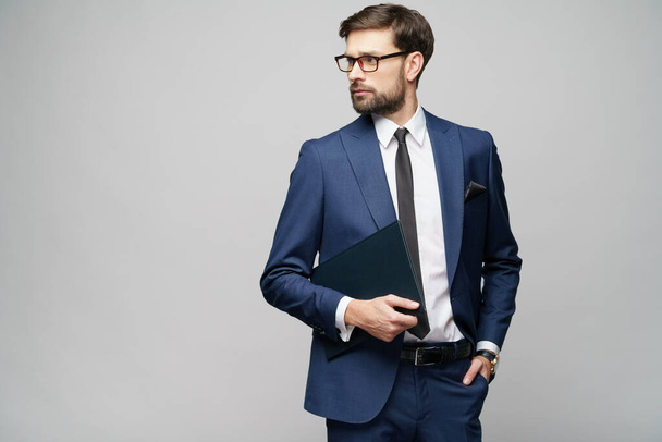 Portrait of a handsome young business man holding document folder - Foto, afbeelding