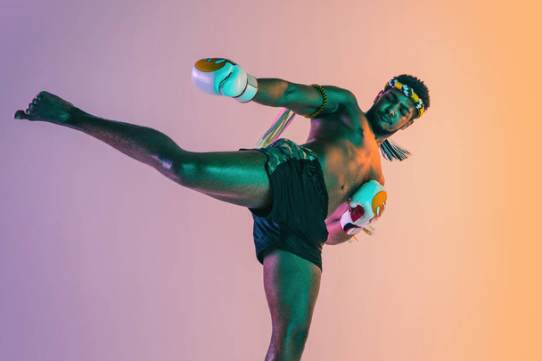 Muay thai. Young man exercising thai boxing on gradient background - 写真・画像