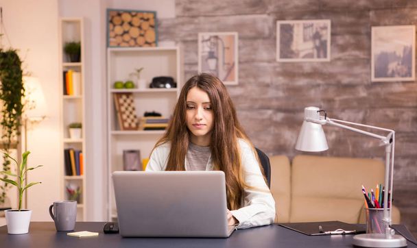 美しい若い女性は自宅のオフィスでノートパソコンで作業 - 写真・画像