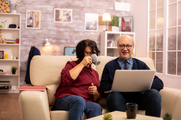 Ancianos pareja de edad utilizando la computadora portátil moderna para charlar con su nieto
 - Foto, imagen
