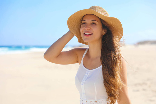 Happy cheerful young woman with straw hat walking on the beach - Fotoğraf, Görsel