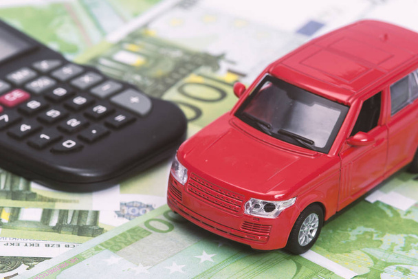 coche rojo y dinero, euros y dólares. concepto de seguro - Foto, Imagen