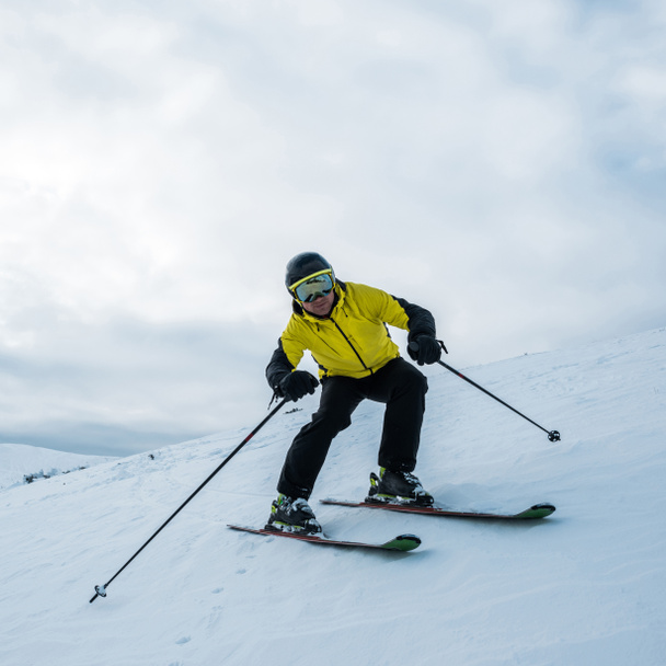 sportif tenant des bâtons de ski tout en skiant sur une pente blanche
 - Photo, image