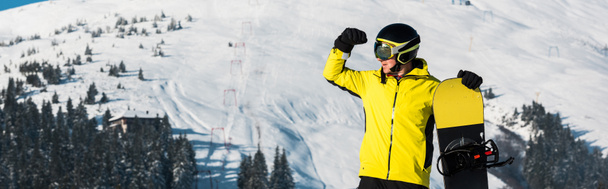 Dağlarda durup gözlerini kaçıran snowboardcunun panoramik görüntüsü. - Fotoğraf, Görsel